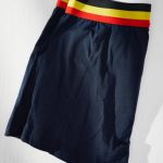Dark blue boxershort with Belgian tricolor waistband. Cotton with 5% elastane. Folded. White wood planks. Light effect. High point of view.